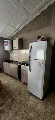 a kitchen with a white refrigerator in a room at CASA SEN in Mina Clavero