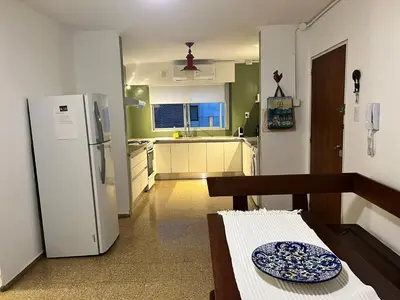 a kitchen with a refrigerator and a plate on a table at Dpto amplio y luminoso en Nva Cordoba in Cordoba