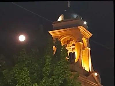 a clock tower at night with a moon in the background at ARROYO SERRANO-MINA CLAVERO in Mina Clavero