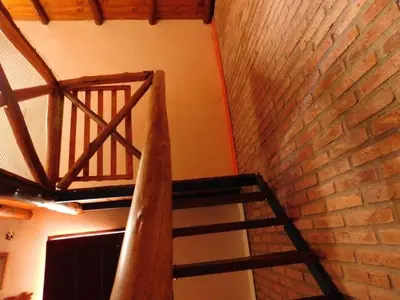 a spiral staircase in a room with a brick wall at Dúplex PIRULO in Villa Cura Brochero