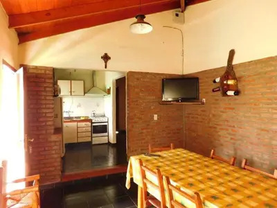 a dining room with a table and a kitchen at Dúplex PIRULO in Villa Cura Brochero