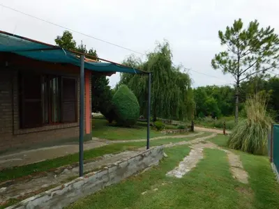 a house with a road next to a building at Dúplex PIRULO in Villa Cura Brochero