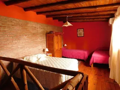 a bedroom with red walls and two beds at Dúplex PIRULO in Villa Cura Brochero