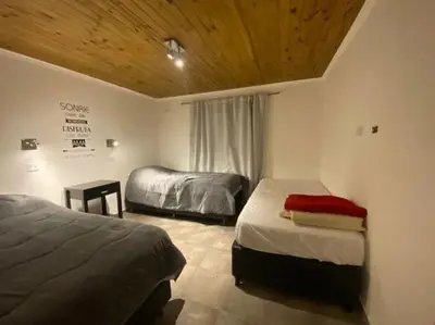 a bedroom with two beds and a wooden ceiling at Palmares - Casas Anisacate in Villa Anizacate
