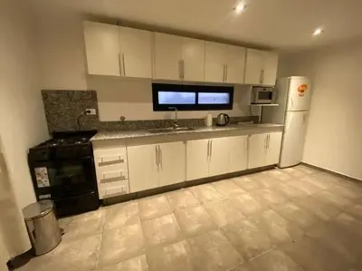 a kitchen with white cabinets and a white refrigerator at Palmares - Casas Anisacate in Villa Anizacate