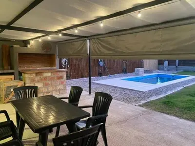 a patio with a table and chairs and a swimming pool at Palmares - Casas Anisacate in Villa Anizacate