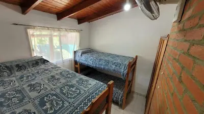 a room with two beds and a window at Mi Recreo CABAÑAS in Villa Cura Brochero