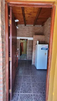 a hallway with a refrigerator in a brick wall at Mi Recreo CABAÑAS in Villa Cura Brochero