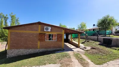 a small brick house with a window and a fence at Mi Recreo CABAÑAS in Villa Cura Brochero