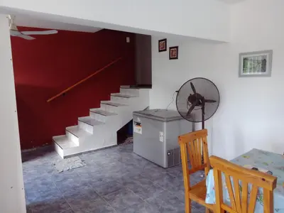 a room with a staircase and a table and a fan at Mi Chalet Carlos Paz - Casa 18 in Villa Santa Cruz del Lago