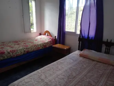 a bedroom with two beds and a window at Mi Chalet Carlos Paz - Casa 18 in Villa Santa Cruz del Lago