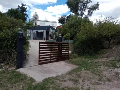 a gate with a fence in front of a building at Mi Chalet Carlos Paz - Casa 18 in Villa Santa Cruz del Lago