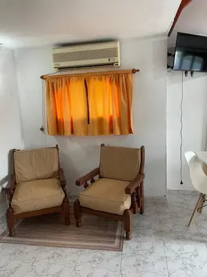 two chairs in a room with a heater and a window at Apartamento Remansum in Santa Rosa de Calamuchita