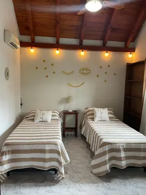 a bedroom with two beds and a face on the wall at Apartamento Remansum in Santa Rosa de Calamuchita