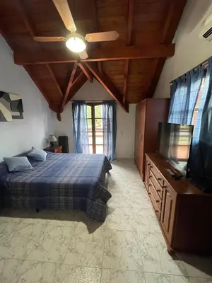 a bedroom with a bed and a flat screen tv at Apartamento Remansum in Santa Rosa de Calamuchita
