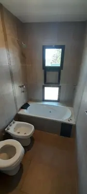 a bathroom with a toilet and a tub and a sink at Acacias Mina Clavero in Mina Clavero