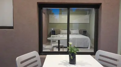 a room with a bed and a table and chairs at Acacias Mina Clavero in Mina Clavero