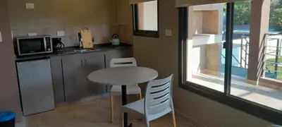 a kitchen with a table and chairs and a window at Acacias Mina Clavero in Mina Clavero