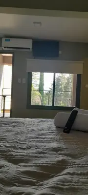 a remote control laying on a bed in a bedroom at Acacias Mina Clavero in Mina Clavero