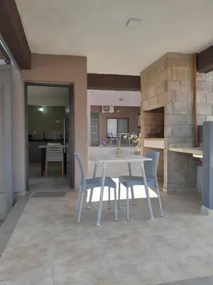 a dining room with a table and chairs and a kitchen at Acacias Mina Clavero in Mina Clavero