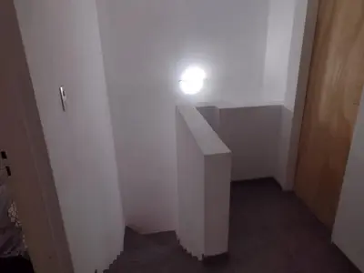 a hallway with a white wall with a light on it at El espinillo in Villa Carlos Paz