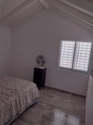 a bedroom with a bed and two windows at El espinillo in Villa Carlos Paz