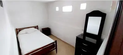 a small bedroom with a bed and a mirror at Lo de Liliana 1 in Tanti