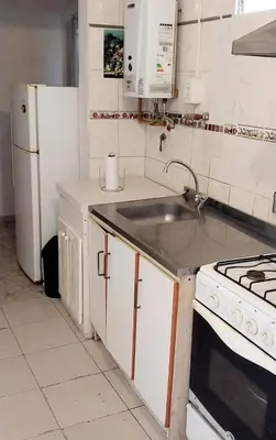 a kitchen with a sink and a white refrigerator at Lo de Liliana 1 in Tanti