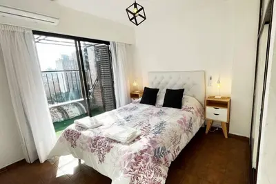 a bedroom with a bed and a large window at Departamento en la mejor zona de Nueva Córdoba in Cordoba