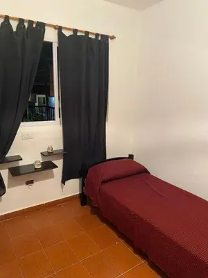 a bedroom with a red bed and a window at departamento céntrico in Villa Carlos Paz