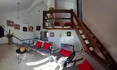 a living room with a staircase with chairs and a couch at Casa con piscina vista al lago montañas-Sierras de Córdoba in Villa Parque Siquiman