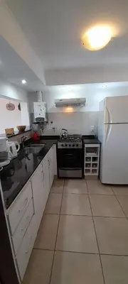 a kitchen with a stove and a refrigerator at Casa con piscina vista al lago montañas-Sierras de Córdoba in Villa Parque Siquiman