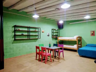 a room with a table and chairs and a bed at El Escarabajo Azul loft & Arte in Villa Carlos Paz