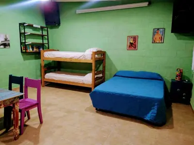 a bedroom with two bunk beds and a table at El Escarabajo Azul loft & Arte in Villa Carlos Paz