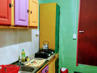 a small kitchen with colorful cabinets and a sink at El Escarabajo Azul loft & Arte in Villa Carlos Paz