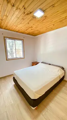 a large bed in a room with a wooden ceiling at Cabañas La Esperanza in Quebrada de los Pozos
