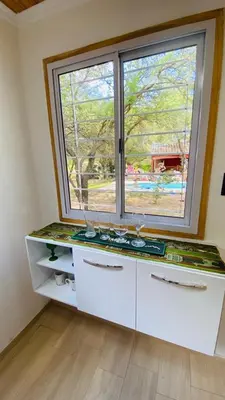 a kitchen with a large window and a counter at Cabañas La Esperanza in Quebrada de los Pozos
