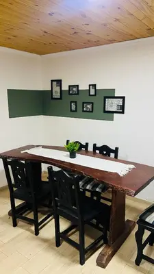 a dining room table with chairs and a table with at Cabañas La Esperanza in Quebrada de los Pozos