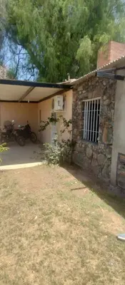 a stone house with a motorcycle parked in front of it at Hospedaje Don Juan in Villa Dolores