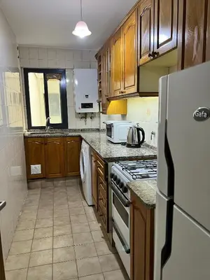 a kitchen with wooden cabinets and a white refrigerator at Apartamento en Colón y Cañada in Cordoba