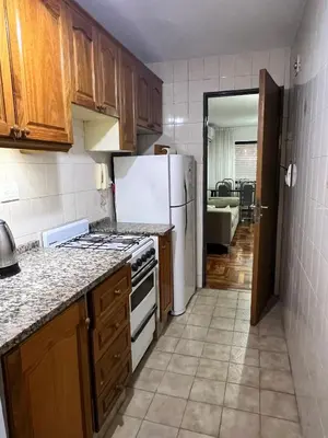 a kitchen with wooden cabinets and a white refrigerator at Apartamento en Colón y Cañada in Cordoba