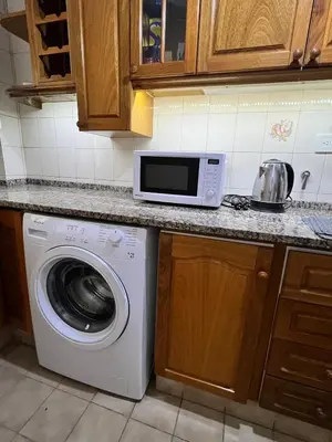 a kitchen with a washing machine and a microwave at Apartamento en Colón y Cañada in Cordoba