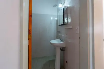 a white bathroom with a sink and a mirror at Departamentos Valle Azul in Santa Rosa de Calamuchita