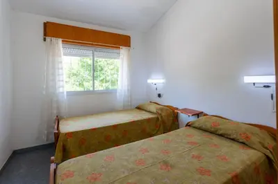 a hotel room with two beds and a window at Departamentos Valle Azul in Santa Rosa de Calamuchita