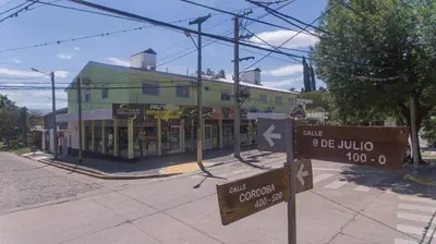 a building on a street with signs in front of it at Departamentos Valle Azul in Santa Rosa de Calamuchita