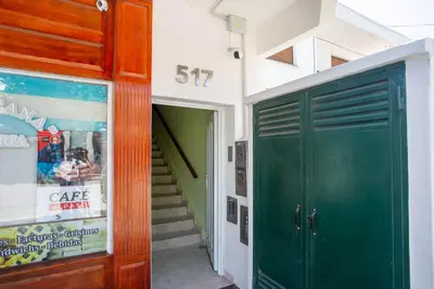 a building with a green door and a staircase at Departamentos Valle Azul in Santa Rosa de Calamuchita