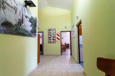a hallway with green walls and tile floors and paintings at Departamentos Valle Azul in Santa Rosa de Calamuchita