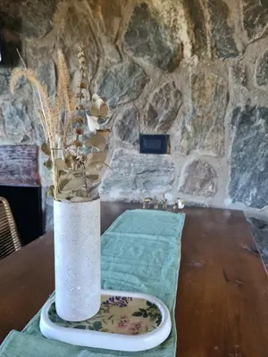 a vase with flowers in it sitting on a table at Chalet - Stone Cabin in Villa Icho Cruz