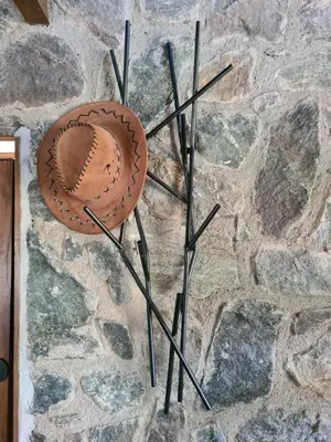 a baseball hat hanging on a stone wall at Chalet - Stone Cabin in Villa Icho Cruz