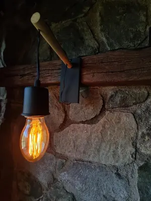 a light hanging from a stone wall with a lantern at Chalet - Stone Cabin in Villa Icho Cruz